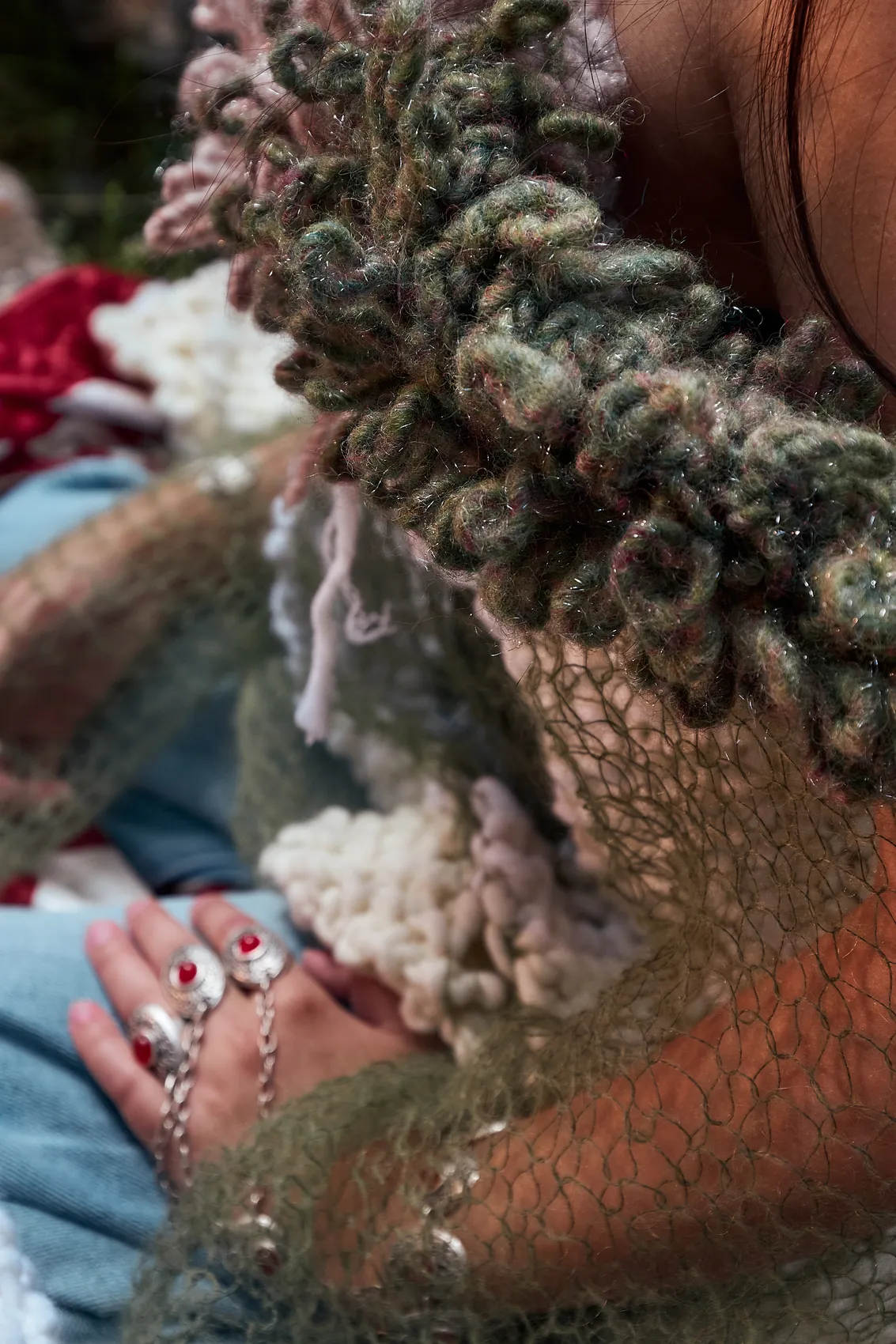 Detail of the looped knit and silver rings