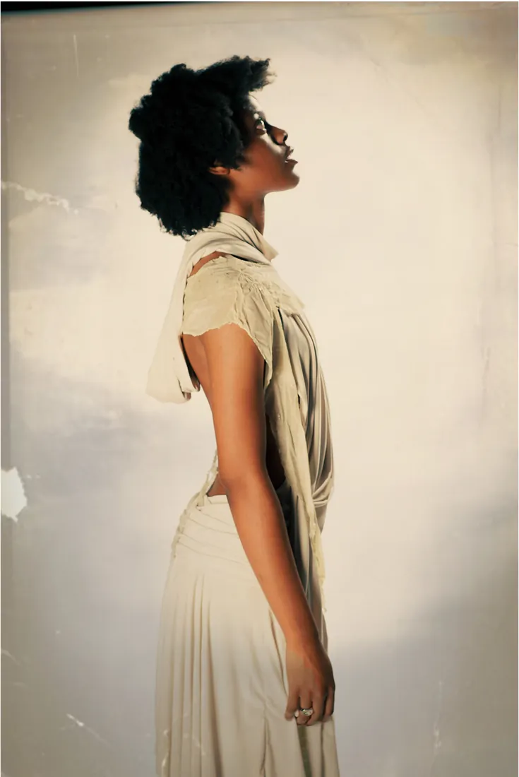 Profile of model in a draped backless dress